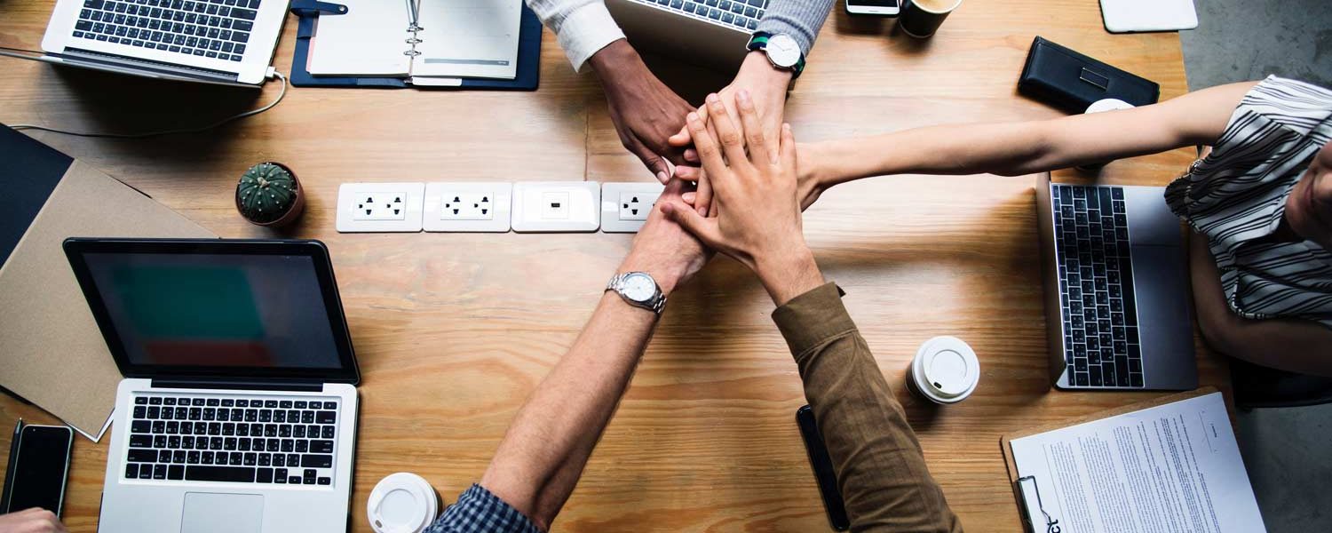 Team hands across the table.